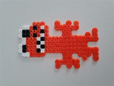 An Orange And Black Piece Of Art Made Out Of Legos On A White Surface