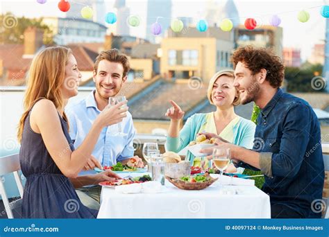 Groupe Damis Mangeant Le Repas Sur La Terrasse De Dessus De Toit Photo