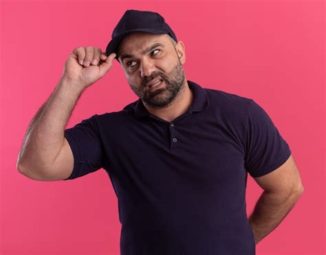 Free Photo Unpleased Middle Aged Delivery Man In Uniform And Cap