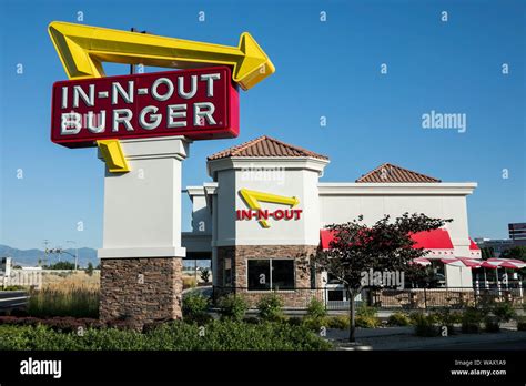 A logo sign outside of a In-N-Out Burger fast food restaurant location ...