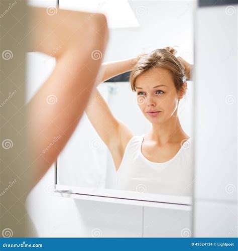 Assez Jeune Femme Devant Son Miroir De Salle De Bains Photo Stock