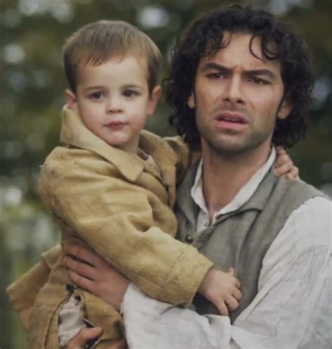 A Man Holding A Young Boy In His Arms