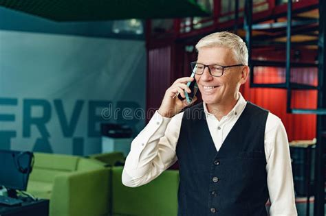 Handsome Mature Businessman Talking On Mobile Phone In The Office Stock
