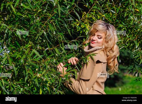 Beautiful Elegant Blonde Woman Dressed In A Coat Standing Under The