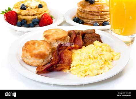 Breakfast plate with scrambled eggs, bacon, and buttermilk biscuits. Waffles, pancakes, and ...