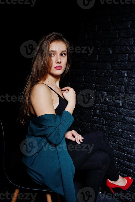 Handsome Brunette Girl Wear On Black And Green Jacket In Red High Heels Sitting And Posing On