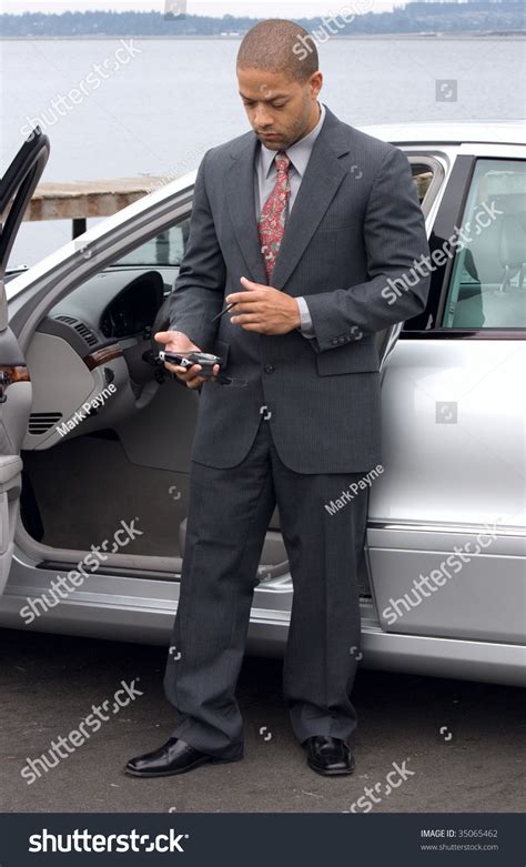 African Business Man Next To Red Car Over Royalty Free Licensable