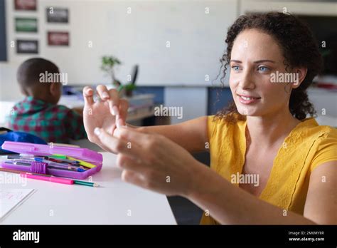 Smiling Caucasian Young Female Teacher Teaching Through Sign Language