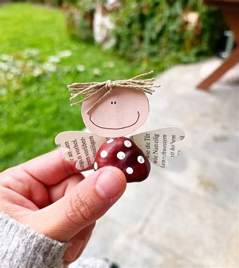 A Person Holding Up A Piece Of Paper With A Lady Bug On It S Side