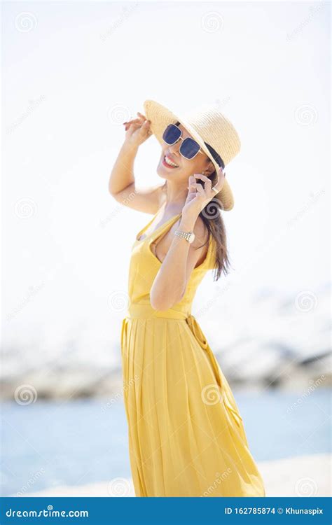 Beautiful Asian Younger Woman Wearing Yellow Dress Relaxing On Summer