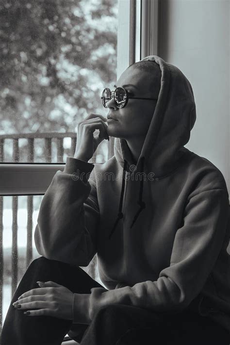 Portrait Of A Young Girl With A Shaved Head In Glasses And A Hood Stock