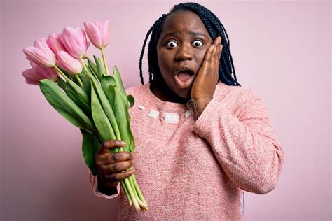 Young African American Plus Size Woman With Braids Holding Bouquet Of