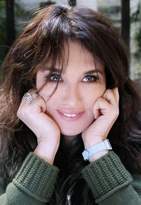 A Close Up Of A Person Wearing A Green Sweater And Holding Her Hands To