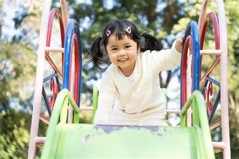 jolie fille asiatique joue dans la cour ou l aire de jeux de l école ou