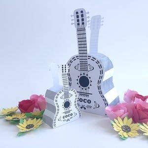 a paper guitar and flowers on a white background