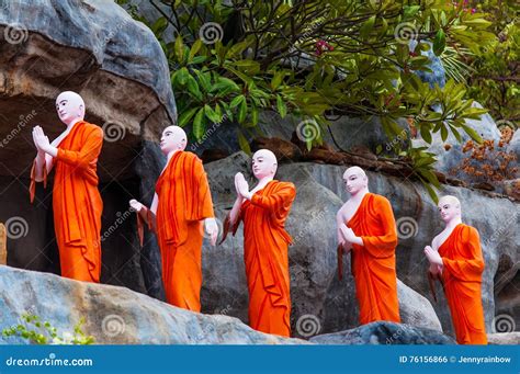 Row Of Buddhist Monk Statues In Orange Monastic Robes Stock Photo