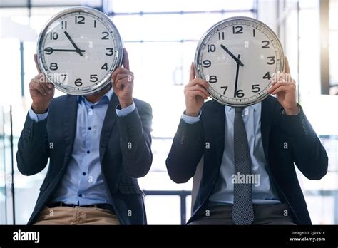 Times A Wasting Two Businessmen Holding Clocks Over Their Faces In The