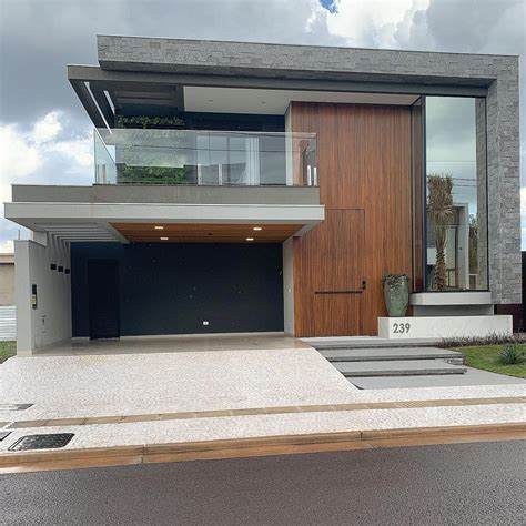 Fachada de casa contemporânea vidro reflecta pedra cinza e painel