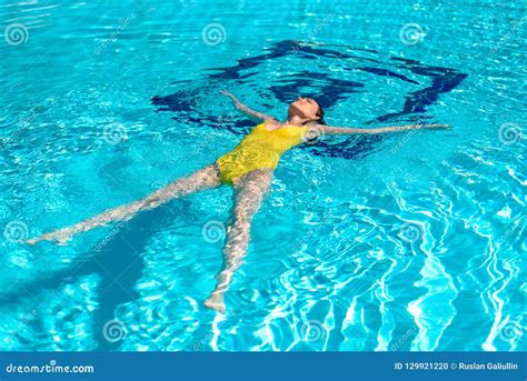 Woman In Yellow Swimsuit Lying On The Water In The Pool Star