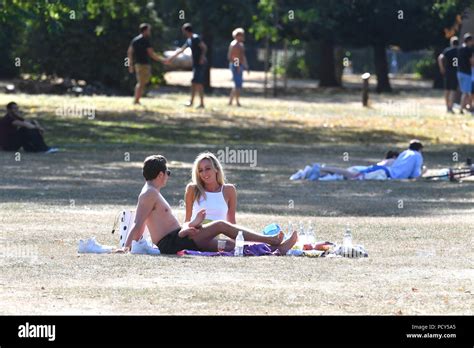People Enjoy The Sunshine At Victoria Park In East London As The Hot