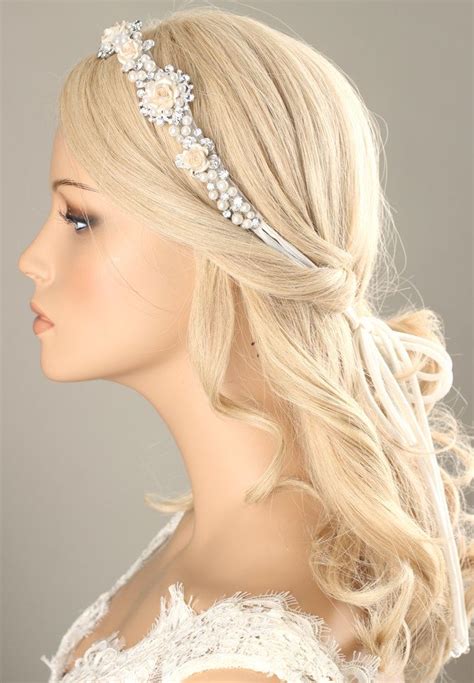 A Woman Wearing A Bridal Headpiece With Flowers On The Side And Pearls