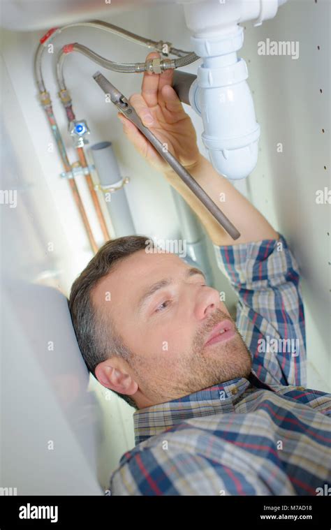 Plumber Repairing A Pipe Under A Sink Stock Photo Alamy