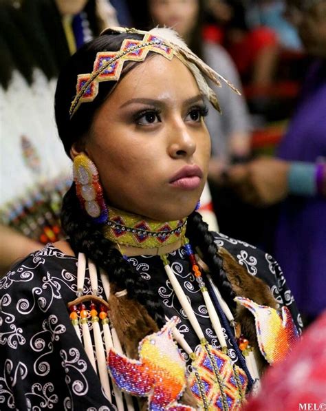 A Woman In An Elaborate Headdress Looks At The Camera