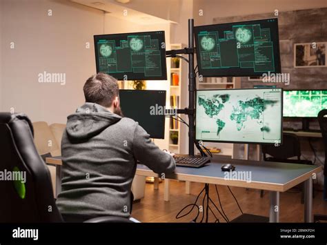 Hacker Writing His Hacking Code On Computer With Multiple Screens In