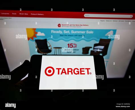 Person Holding Mobile Phone With Logo Of American Retail Company Target