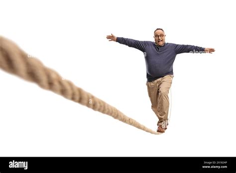 Full Length Portrait Of A Mature Man Walking On A Rope Isolated On