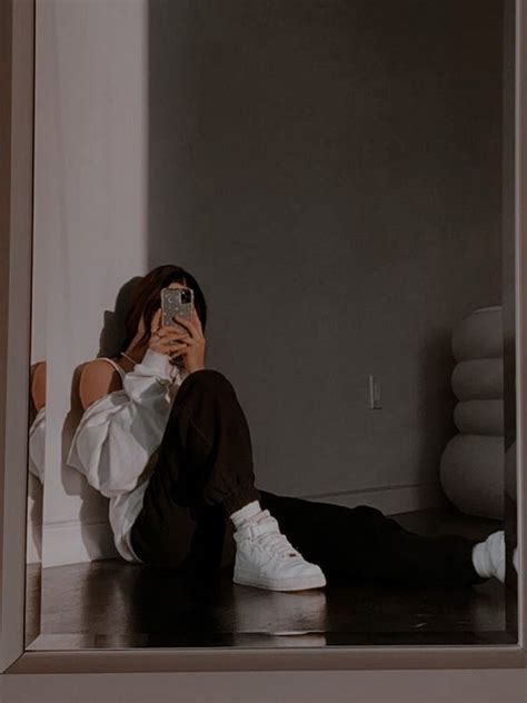 A Person Sitting On The Floor Taking A Selfie