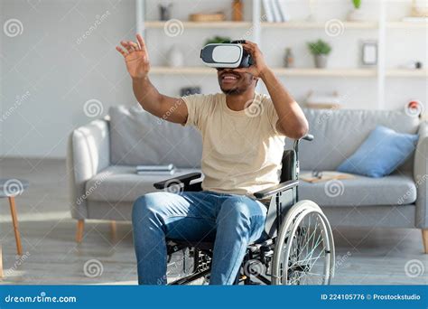 Disabled Young Black Man In Wheelchair Exploring Augmented Reality In