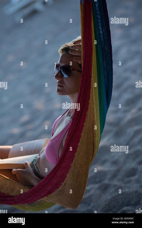 Relaxed Woman Laying In Hammock Bed On Beach And Enjoy Sunset While