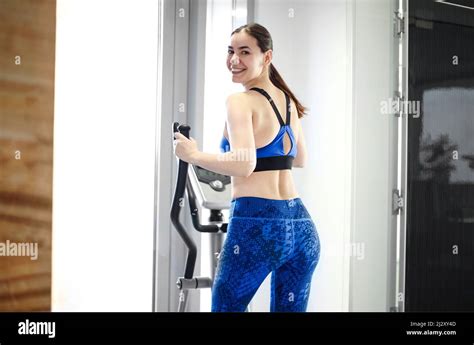 Smiling Athletic Brunette Woman Dressed In A Black Sportswear Running On The Treadmill In The