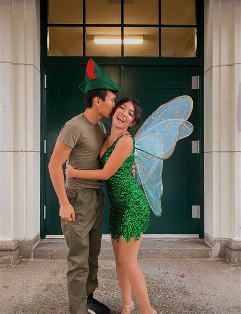 A Man And Woman Dressed Up As Tinkerbells Pose For A Photo In Front Of