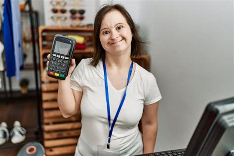 Brunette Woman With Down Syndrome Working As Shop Assistant Holding