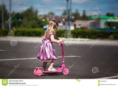 Menina No Vestido Que Monta Seu Trotinette No Parque Summertime