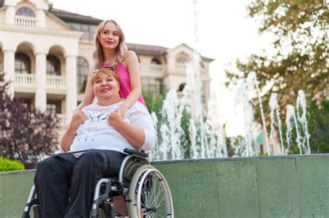 Premium Photo Young Daughter Taking Care Of Her Mother Sitting In Wheelchair