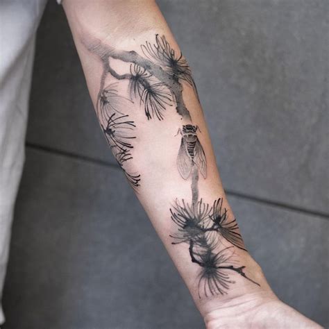 A Person With A Tattoo On Their Arm That Has Dandelions In The Middle