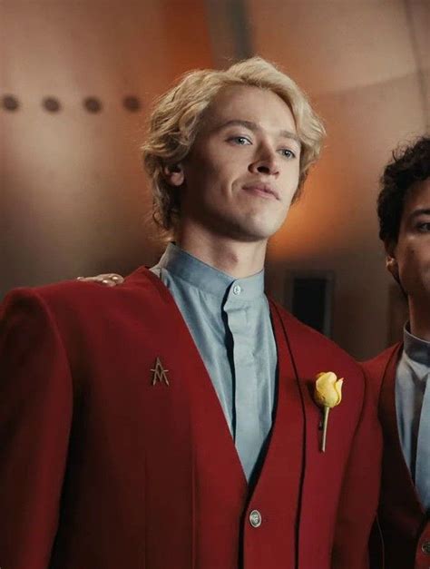 Two Men Dressed In Red Suits And One Is Wearing A Yellow Rose On His Lapel