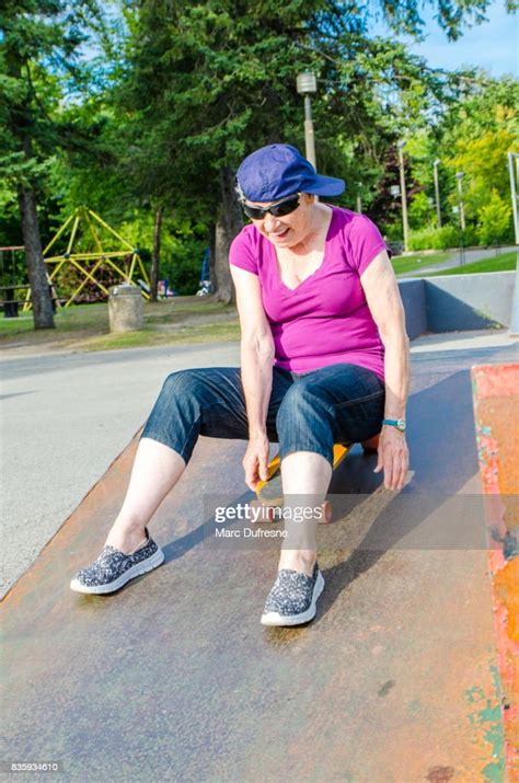 Senior Woman Wearing Baseball Cap On The Side And Sitting On Skateboard