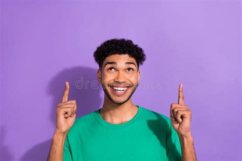 Photo Of Funny Interested Youngster Guy Direct Fingers Look Up Empty Space Wear Green Shirt