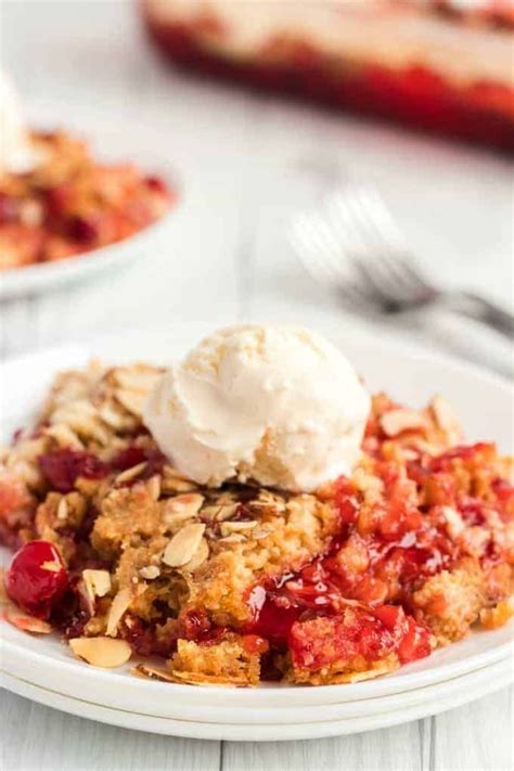 Cherry Dump Cake With Vanilla Ice Cream On Top On A White Plate