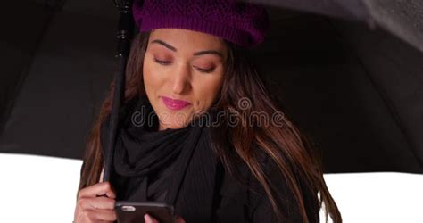 Close Up Of Latina Female Holding Umbrella And Texting On Phone In