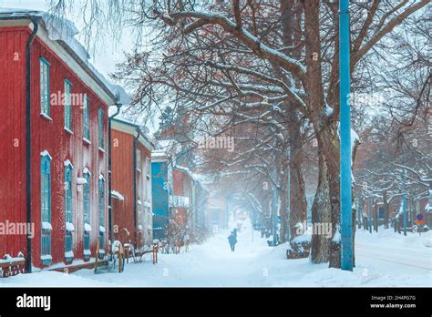 Winter snowstorm. People walking snowy street with old colorful houses ...