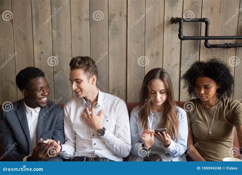 Millennial Multiracial Friends Using Mobile Phones And Talking A Stock