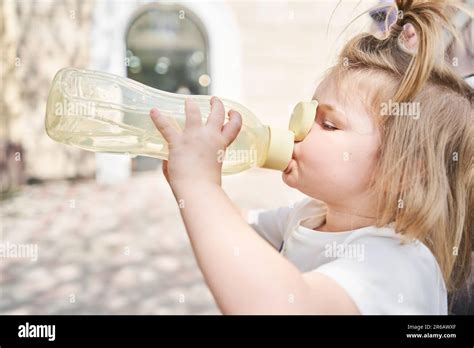 Une Charmante Petite Fille Boit L Eau D Une Bouteille De Sport Dans Un