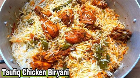 A Pan Filled With Chicken Biriyani Next To Rice And Carrots On A Wooden