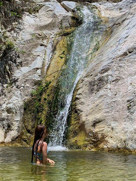 A Girls Back Is Turned As She Swims Under A Waterfall Summer Swim