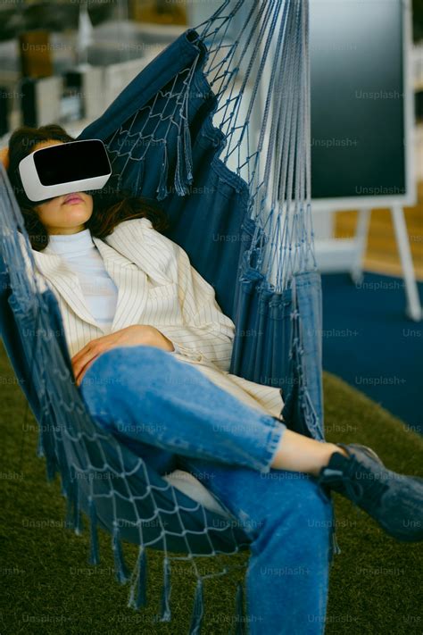 가상 헤드셋을 착용하고 테이블에 앉아 있는 여성 사진 Unsplash의 Vr 헤드셋 이미지